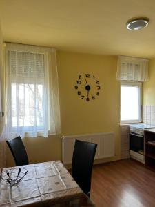 a dining room with a clock on the wall at Szekcsői Kuckó in Kaposszekcső