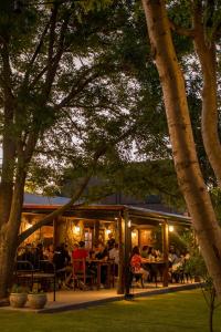 a group of people sitting at tables in a restaurant at Finca La Marta - El Cortijo Wine Lodge in Capilla del Monte