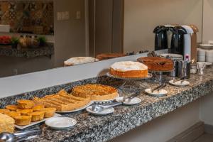 ein Buffet mit Kuchen und Torten auf einer Theke in der Unterkunft Minuano Hotel Express próx Orla Lago Guaíba, Mercado Público, 300 m Rodoviária in Porto Alegre