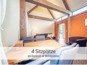 a dining room with a table and a couch at Dolly Dur - Mini Ferienhaus in Kyritz, einer charmanten Stadt im Herzen von Brandenburg in Kyritz