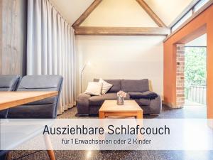 a living room with a couch and a table at Dolly Dur - Mini Ferienhaus in Kyritz, einer charmanten Stadt im Herzen von Brandenburg in Kyritz