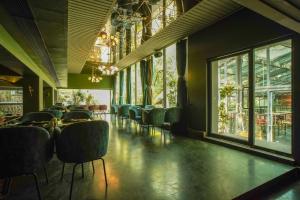 a dining room with chairs and tables and windows at Open Hotel by Olive - Slate in Chennai