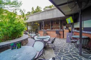 a patio with tables and chairs and a bar at Open Hotel by Olive - Slate in Chennai