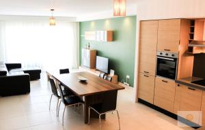 a kitchen and dining room with a wooden table at Bayview Seafront 5A in St. Julianʼs +12 photos