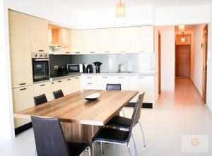 a kitchen with a wooden table and chairs at Bayview Seafront 5A in St. Julianʼs