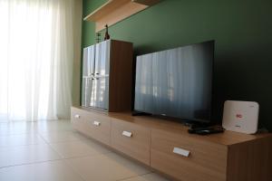 a flat screen tv sitting on top of a wooden cabinet at Bayview Seafront 5A in St. Julianʼs