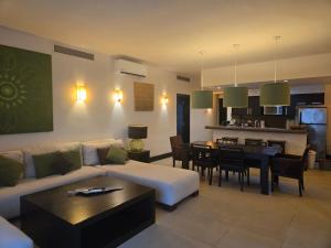 a living room with a couch and a dining room at Awesome apartment at Aldea Thai Beachfront in Playa del Carmen
