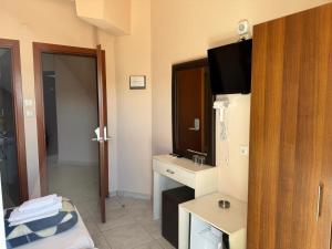 a hotel room with a television and a bathroom at Plaza Hotel in Hanioti