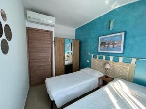 a bedroom with two beds and a blue wall at Villa Lavinia in Alghero +62 photos