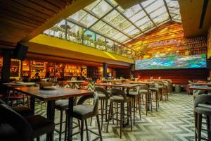 a restaurant with tables and chairs and a glass ceiling at Open Hotel by Olive - Slate in Chennai