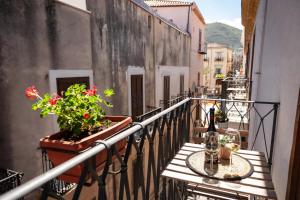 a balcony with a table and a bottle of wine at Duomo Apartments Affittacamere in Cefalù