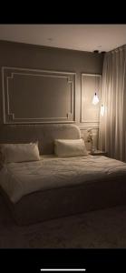 a bedroom with a large bed and a lamp at غرفتين وصالة بدخول ذكي in Al Kharj