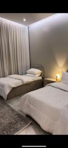 two beds sitting next to each other in a bedroom at غرفتين وصالة بدخول ذكي in Al Kharj