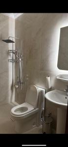 a white bathroom with a toilet and a sink at غرفتين وصالة بدخول ذكي in Al Kharj