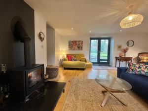 a living room with a fireplace and a couch at Crymlyn barn in Llanwrda