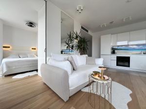 a living room with a white couch and a bedroom at DeLux Apartment Koper - NEW in Koper