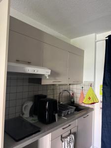 a kitchen with white cabinets and a sink at Studio dans résidence avec piscine in Bidart