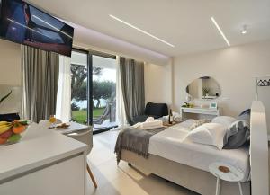 a bedroom with a large bed and a large window at Blue Residences in Paralia Vrachou