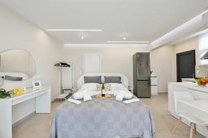 a white bedroom with a bed and a sink at Blue Residences in Paralia Vrachou