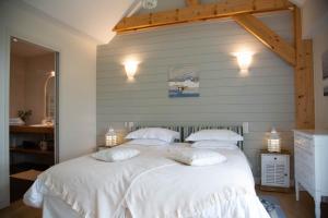 a bedroom with a large white bed with two pillows at Kerlenn in Baden