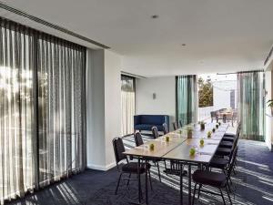 a conference room with a long table and chairs at Novotel Geelong in Geelong