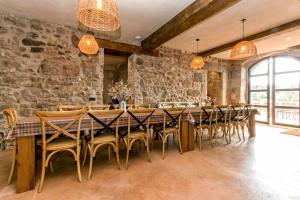 a large dining room with a long table and chairs at El Mas de Mateus in Sagás
