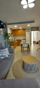 a living room with a couch and a table and a kitchen at Pont de Ferro Sunny Flat - Mediterránea Sunny Keys in Benicàssim