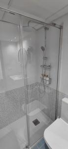 a bathroom with a glass shower with a toilet at Pont de Ferro Sunny Flat - Mediterránea Sunny Keys in Benicàssim