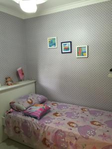 - une chambre avec un lit recouvert de papier peint à point de polka dans l'établissement Apartamento Spiaggia Del Sole, à Guarujá