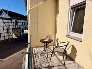 a patio with two chairs and a table on a balcony at Aparthotel Zur Linde - by Willms & Schömer eG in Euskirchen