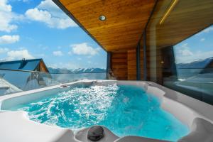 a bath tub with blue water in a boat at Salamandra Luxury Villas with Jacuzzi by BQQK in Kościelisko