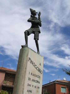 uma estátua de um rapaz em cima de um cartaz em 4 PINI em Ancona