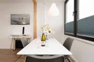 a white table with a bottle of wine and flowers on it at Marina Wendtorf Oase in Wendtorf