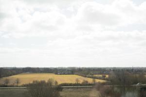 an open field with a farm in the distance at Marina Wendtorf Oase in Wendtorf +12 photos