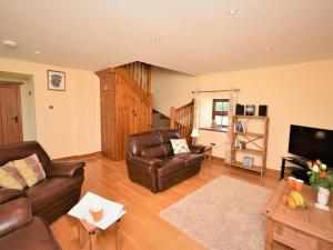 a living room with two leather chairs and a television at 2 Bed in Mold oc-41656 in Caerwys