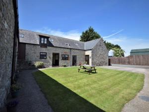 a stone house with a picnic table in the yard at 2 Bed in Mold oc-41656 in Caerwys