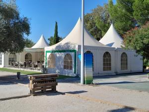 a white tent with a bench in front of it at Camping Fontisson in Châteauneuf-de-Gadagne