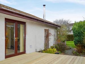 a house with a wooden deck in front of it at March Brown in Garmouth +11 photos