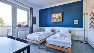 a hotel room with two beds and a table at Private Rooms Karlsruhe near station in Karlsruhe