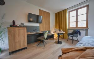 ein Schlafzimmer mit einem Bett und einem Schreibtisch mit Computer in der Unterkunft Unser Hotel in Eggenfelden + 17 Fotos