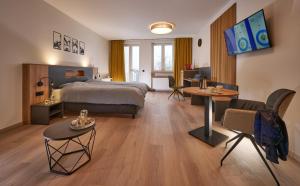 ein Hotelzimmer mit Bett, Tisch und Stühlen in der Unterkunft Unser Hotel in Eggenfelden