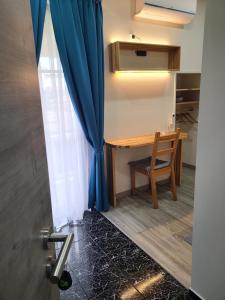 a room with a table and a blue curtain at Calma do Mar in Madalena