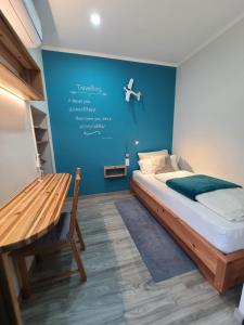 a bedroom with a bed and a blue wall at Calma do Mar in Madalena