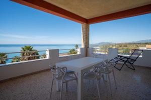 a balcony with a table and chairs and the ocean at Suliventumari in Ribera