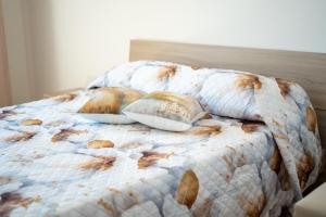 a bed with a comforter with two pillows on it at Suliventumari in Ribera
