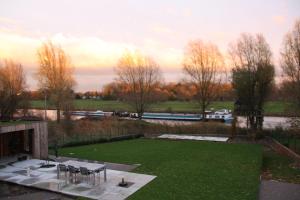 a patio with chairs and a green lawn at B&B The View Bis in Kortrijk