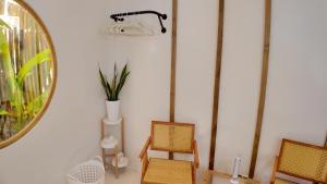 a room with two chairs and a table and a mirror at Bom Dia Siargao Villas in General Luna