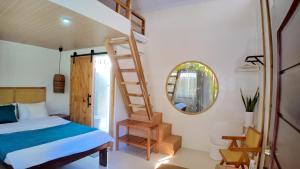 a bedroom with a bed and a ladder and a mirror at Bom Dia Siargao Villas in General Luna