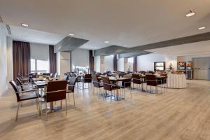 a restaurant with tables and chairs in a room at iH Hotels Roma Z3 in Rome