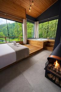 a bedroom with a tub and a bed and a fireplace at Refúgio do Vale Estalagem in Annitapolis